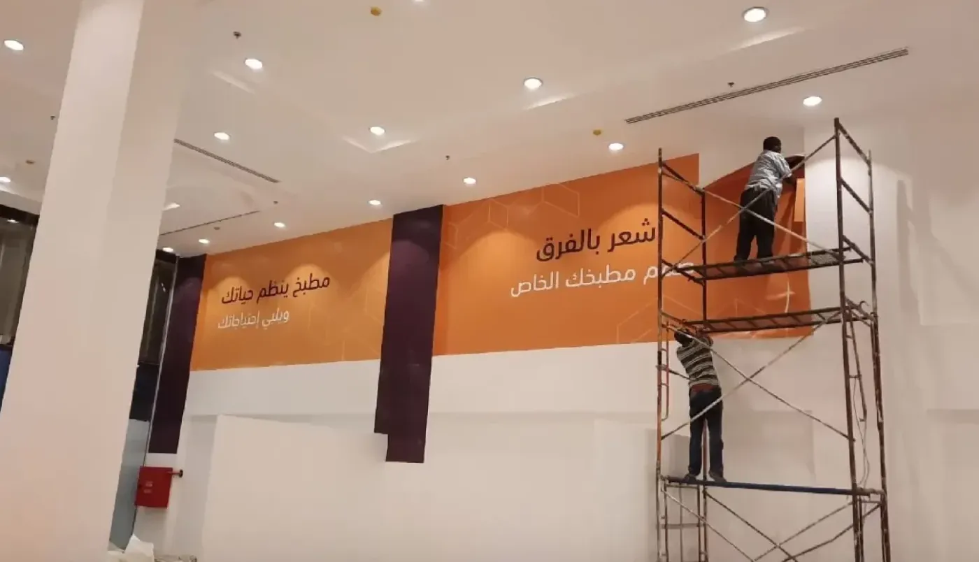 لوحة جدارية إعلانية كبيرة أثناء التركيب في مطعم